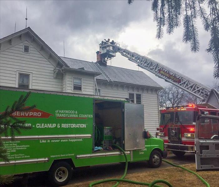 SERVPRO truck and fire truck in front of a Marion house that is experiencing fire damage
